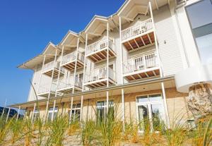 a white building with balconies on the beach at Easy Living in List