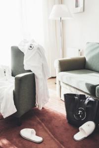 a living room with a couch and a chair with a towel at Reduce Hotel Vital in Bad Tatzmannsdorf