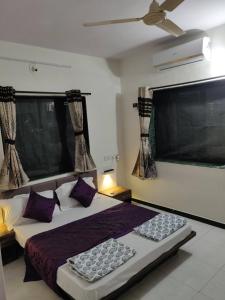 a bedroom with a bed and a large window at villas holiday family home service in Surat