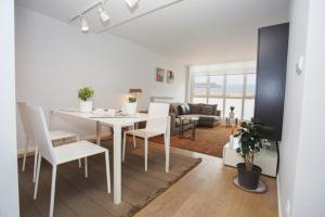 comedor y sala de estar con mesa blanca y sillas en Orio playa lucirá, en Orio