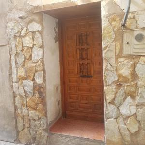 a wooden door in a stone building with a stone wall at Apartamento CabezoDoce in Calahorra