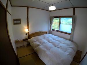 a bedroom with a white bed and a window at NORD 2 in Iwamizawa