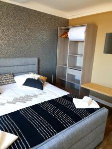 a bedroom with a large bed and a shelf at Appartement sur la Plage 4 Personnes in Arromanches-les-Bains