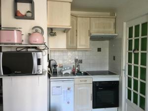 een keuken met een koelkast en een magnetron bij Plage et Mer Service Tout Compris in Cabourg
