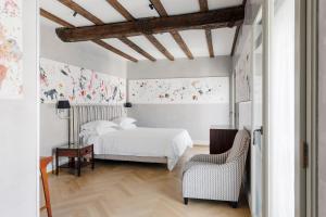 a bedroom with a bed and a chair at Galleria Vik Milano - Townhouse Galleria - Small Luxury Hotels of the World in Milan
