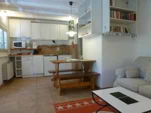 eine Küche und ein Wohnzimmer mit einem Sofa und einem Tisch in der Unterkunft LE COTTAGE in Ailhon