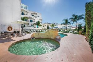 a swimming pool in the middle of a resort at Velamar Boutique Hotel - Adults Friendly in Albufeira