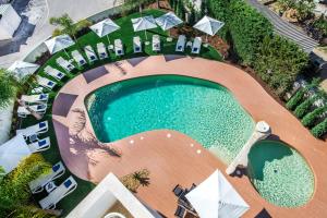 an overhead view of a swimming pool with umbrellas and chairs at Velamar Boutique Hotel - Adults Friendly in Albufeira