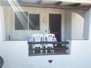 una mesa y sillas en el porche de una casa en Residence La Conia, en Cannigione
