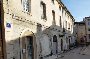 un vieux bâtiment sur une rue avec un panneau d'arrêt dans l'établissement Magnifique duplex vue Palais des Papes près de Pont d'Avignon, à Avignon
