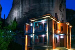 a building in front of a mountain at night at Elia Deluxe Accommodation in Kalabaka