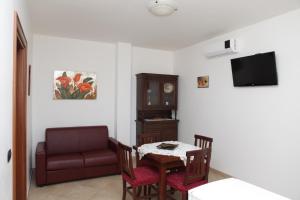 sala de estar con mesa y sofá en B&B Parcomonsignore, en San Vito dei Normanni