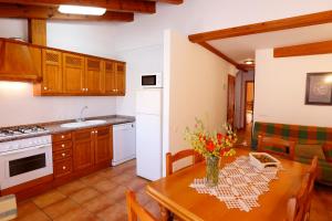 uma cozinha e sala de jantar com uma mesa com flores em Casa Enpiera III - Turistrat em Cinctorres