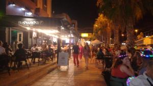 un groupe de personnes assises à l'extérieur d'un restaurant la nuit dans l'établissement Apartamento Playa Mar 303, à Playas de Orihuela 47 autres photos