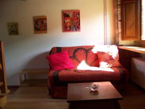 sala de estar con sofá y almohadas rojas en Torre Tanquián Eco Finca - Ribeira Sacra, en Pantón