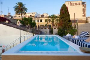 een zwembad met ligstoelen naast een gebouw bij MHOUSE Boutique Hotel Palma in Palma de Mallorca