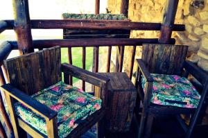 duas cadeiras de madeira sentadas em cima de um alpendre em Cheetau Lodge em Ebenhaezer