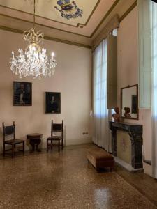 ボローニャにあるPalazzo Bargellini Panzacchi Rooms & Apartmentのリビングルーム(シャンデリア、暖炉付)