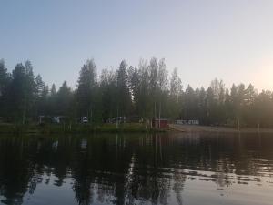 una gran masa de agua con árboles en el fondo en Camping Atrain, en Kuopio