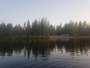 una gran masa de agua con árboles en el fondo en Camping Atrain, en Kuopio