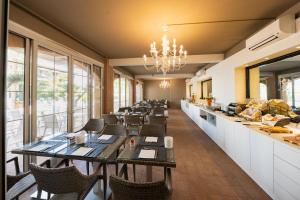 a restaurant with tables and chairs and a counter at Park Hotel Pineta in Caorle