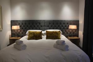 a large white bed with two pillows and two lamps at Apt 2, Frasers Close in Kirkwall