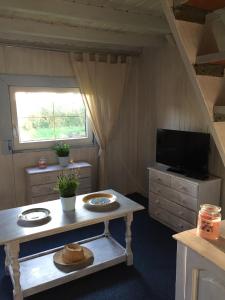 Kleines Zimmer mit einem Tisch und einem TV. in der Unterkunft Domek nad jeziorem Otalżyno in Pomieczyno