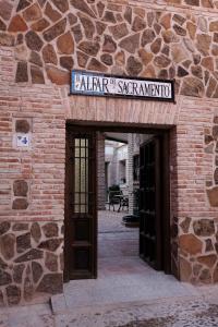 a brick building with a sign over a door at Apartmentos El Alfar del Sacramento in Toledo