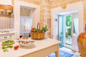 a kitchen with a counter with a basket of vegetables on it at Palazzo Tre Cardi in Salve +51 photos