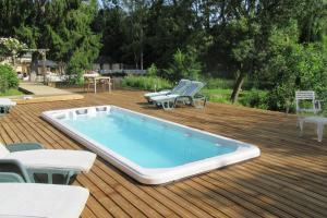 una piscina en una terraza con sillas y mesa en Le Moulin Calme, en Luceau