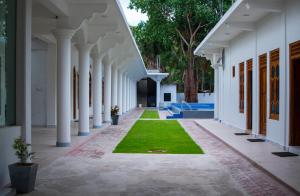 a corridor of a building with grass in the middle at MRD Beach Hotel in Trincomalee