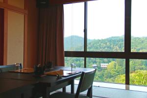 吉野的住宿－景勝芳雲日式旅館，一间带桌子和大窗户的用餐室