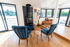 un salon avec des chaises bleues et une cheminée dans l'établissement La Rivière House - Péniche Carpe Diem, à Nantes