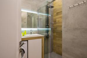 een badkamer met een wastafel en een glazen douche bij Sofievskaya Apartments in Kiev