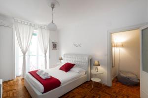 a bedroom with a white bed and a window at Casa Volver in Rome