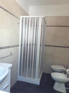 a bathroom with a toilet and a glass shower door at La casa di Mela in Leverano +3 photos