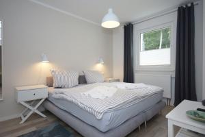 ein Schlafzimmer mit einem Bett und einem Fenster in der Unterkunft Ferienwohnung Windherz in Ostseebad Sellin