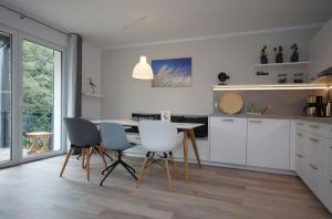 eine Küche mit Tisch und Stühlen in einem Zimmer in der Unterkunft Ferienwohnung Windherz in Ostseebad Sellin
