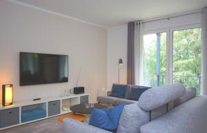 ein Wohnzimmer mit einem Sofa und einem Flachbild-TV in der Unterkunft Ferienwohnung Windherz in Ostseebad Sellin