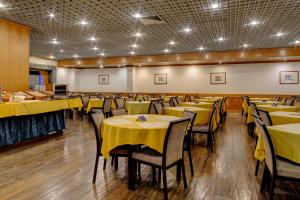 uma sala de jantar com mesas e cadeiras amarelas em VIP Inn Berna Hotel em Lisboa
