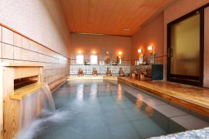 吉野的住宿－景勝芳雲日式旅館，一座室内游泳池,位于一座建筑中,设有瀑布