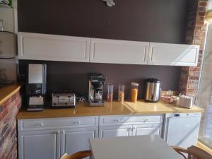 a kitchen with white cabinets and a counter with a coffee maker at Hotel Na Šustně in Krupá