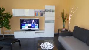 uma sala de estar com televisão num centro de entretenimento branco em Ferienhaus Scharmützelsee em Wendisch Rietz