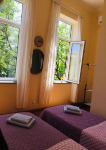 2 camas en un dormitorio con 2 ventanas en Guest House Hello en Kutaisi