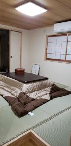 uma cama num quarto com uma mesa em cima em GardenRoom bnb Yumyum em Nagasaki