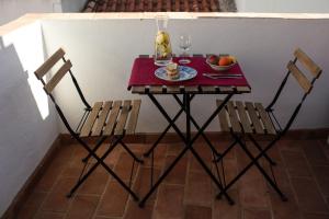 Una mesa pequeña con dos sillas y un bol de fruta. en Typical fishing village in historic center I, en Portimão