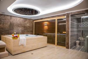 a large bathroom with a tub and a shower at Suna Sun Hotel - Adult Only in Kas