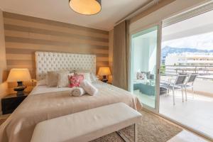 sypialnia z dużym łóżkiem i balkonem w obiekcie VACATION MARBELLA I Brand New Terrazas de Banús Apt, 24-7 Security, a minute from the Marina, The Sea and Luxury Shopping w Marbelli
