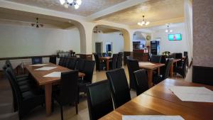un ristorante con tavoli in legno e sedie nere di Pensiunea Versant a Băile Herculane