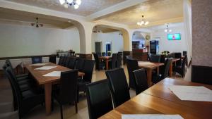 a restaurant with wooden tables and black chairs at Pensiunea Versant in Băile Herculane